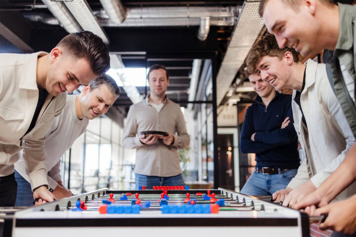 Collega Stef en jij kijken naar het potje tafelvoetbal van collega's