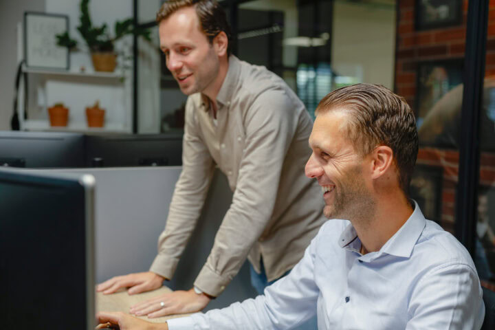 Ai Voor Marketing Automatiseer Processen En Werk Sneller Een Afbeelding Van Twee Collega's Die Samen Kijken Naar Een Computer
